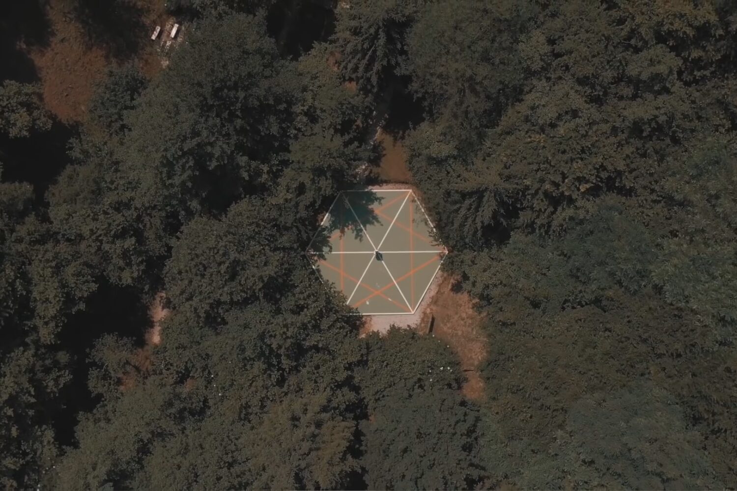 Aerial view of a hexagonal meditation platform surrounded by dense forest at the Bosnian Pyramid complex.