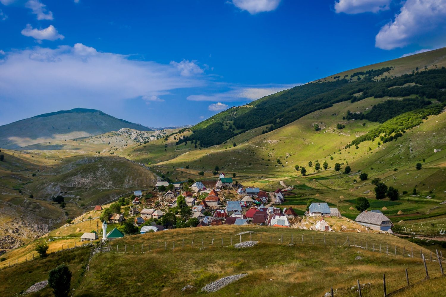 Scenic view of Lukomir village nestled in the mountains with clear blue skies