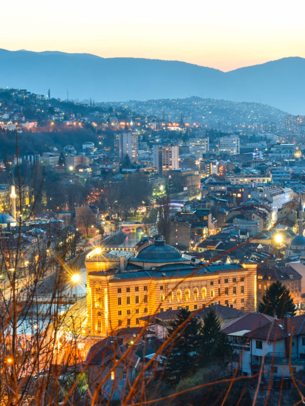 Night view of Sarajevo with city lights and surrounding mountains