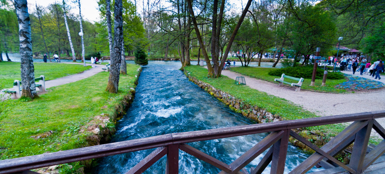 Scenic view of Vrelo Bosne with clear blue waters and lush greenery