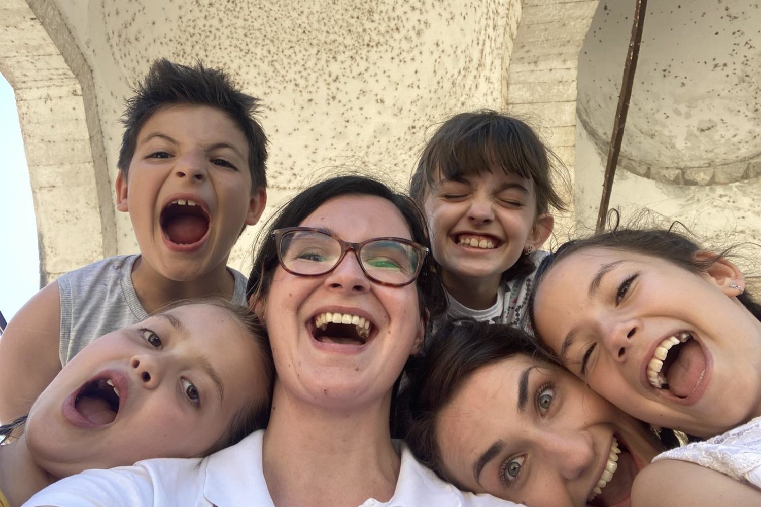 Group of smiling children and two adults taking a selfie
